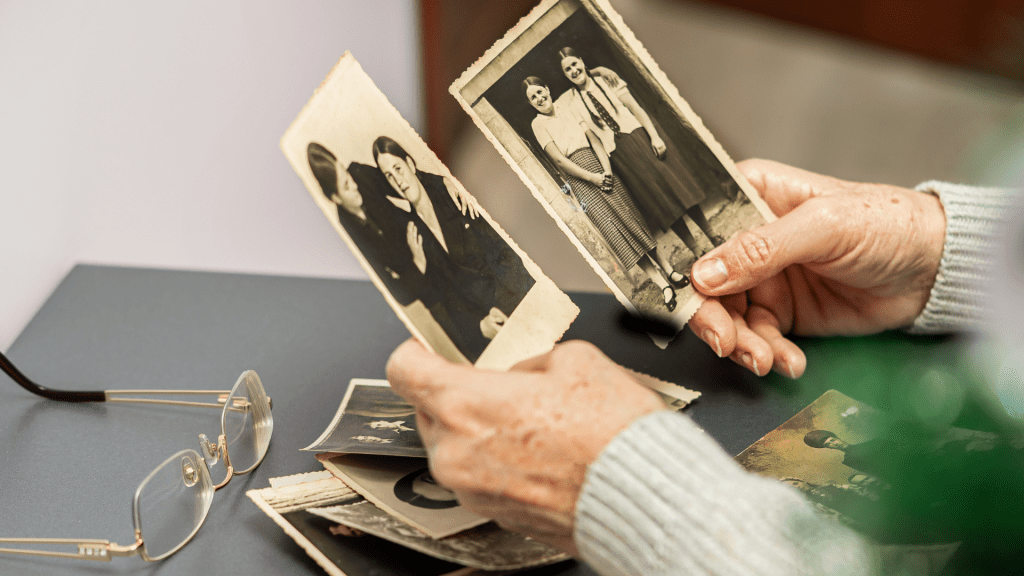 Elderly person preparing photos for audio visual tribute